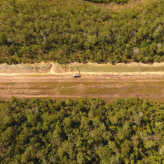 Drone Shot of Spray Grass Australia HydroRig spraying hydroseeding mixture onto site, surrounded by vegetation